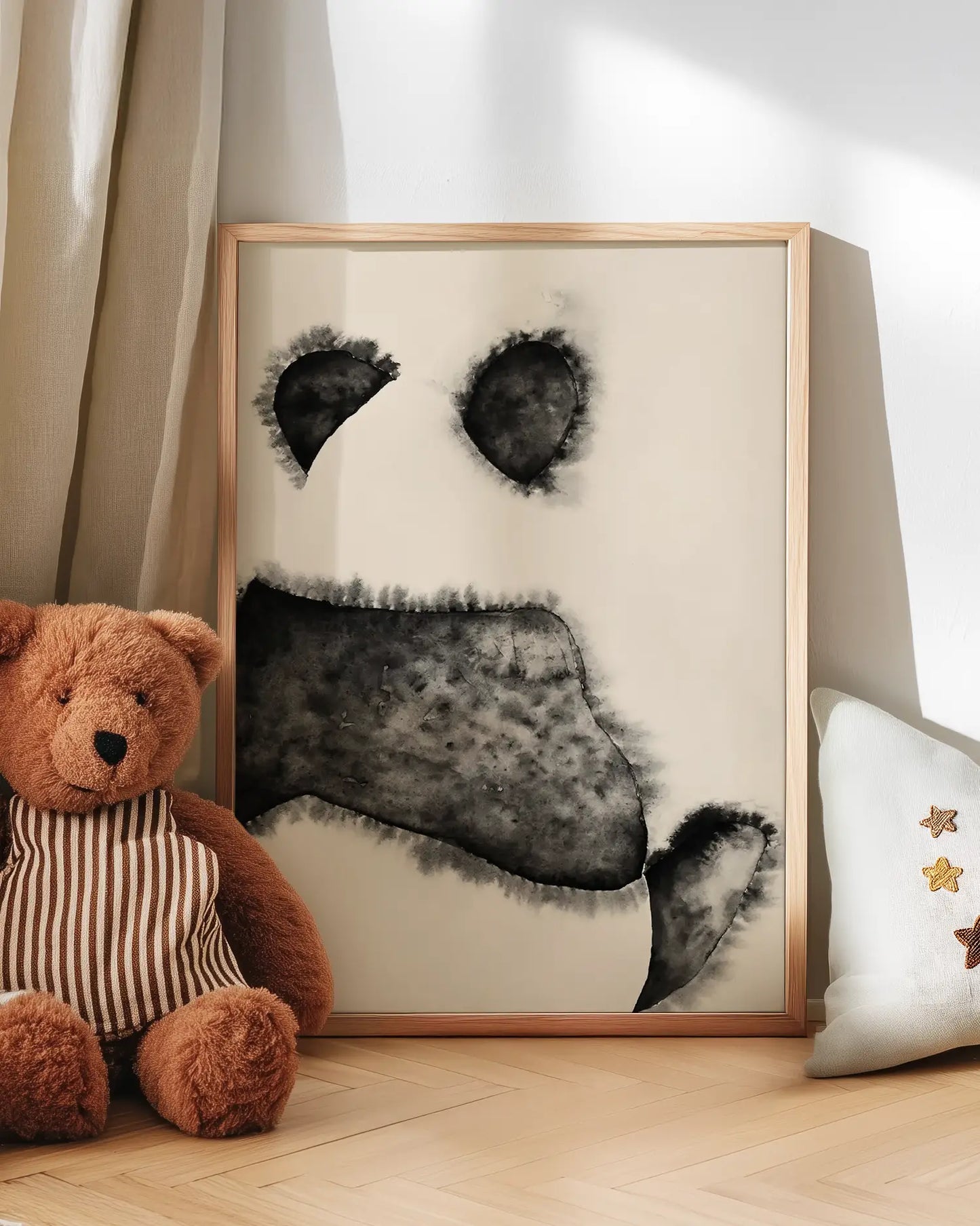 Art piece of a panda on a wall with a teddy bear and decorative pillow.