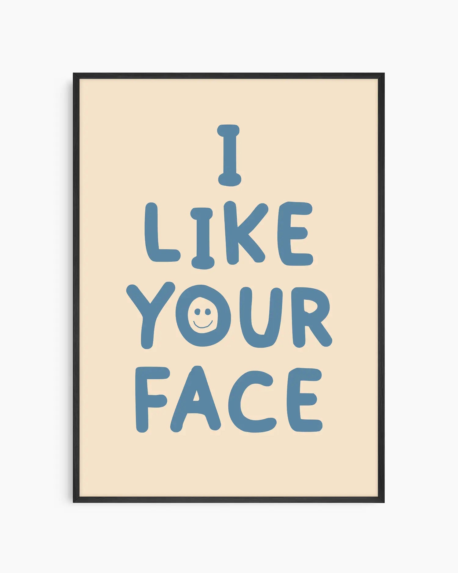 Beige nursery poster with the text 'I like your face' written in blue, framed in a black frame.