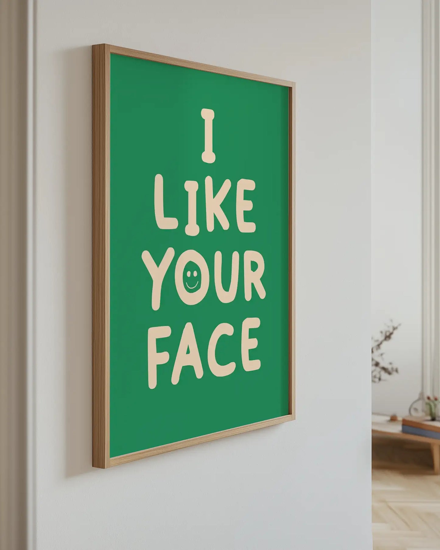 Green artwork with 'I Like Your Face' text, mounted on a wall.