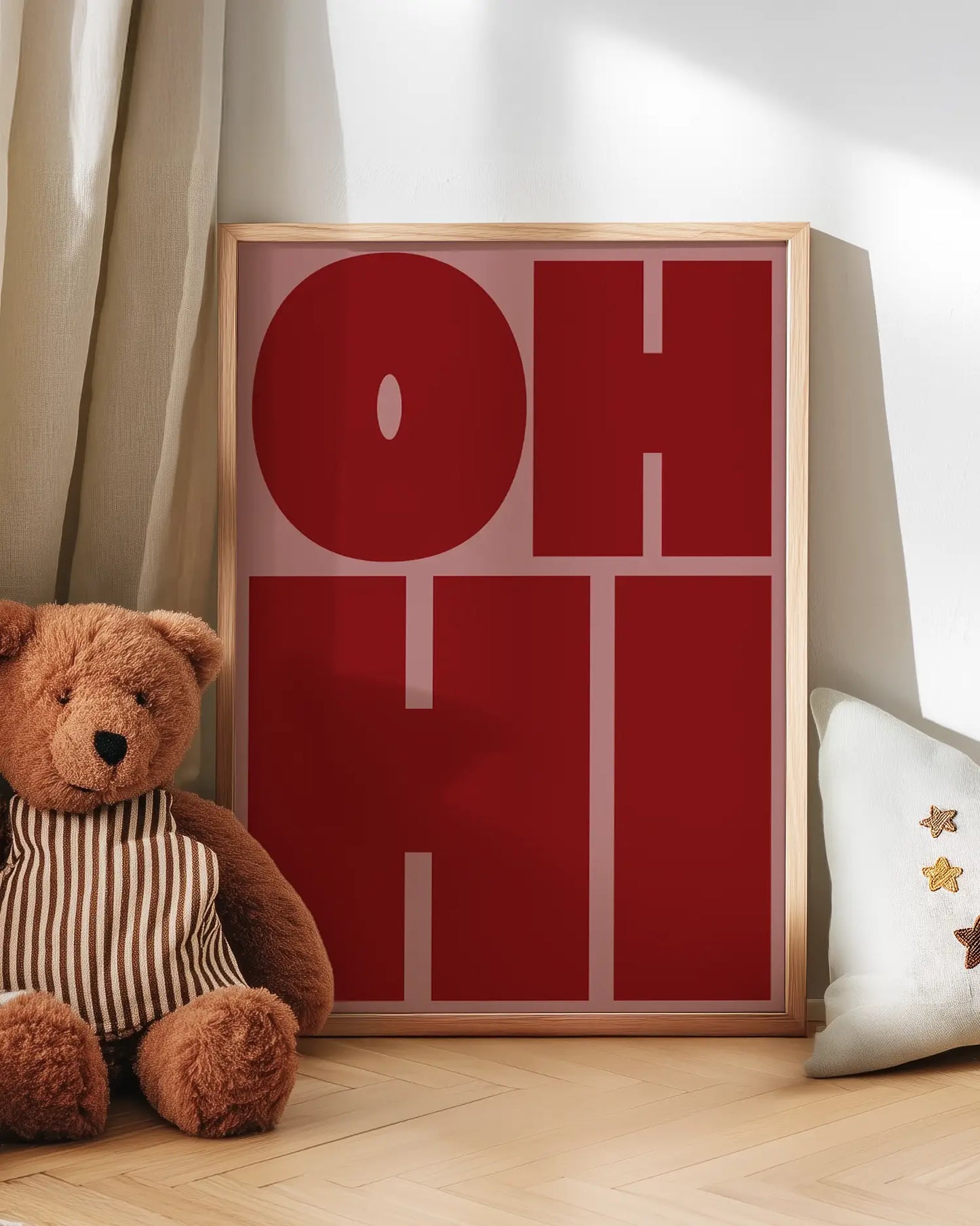 Pink and red artwork with 'OH HI' text next to a teddy bear on a wooden floor.