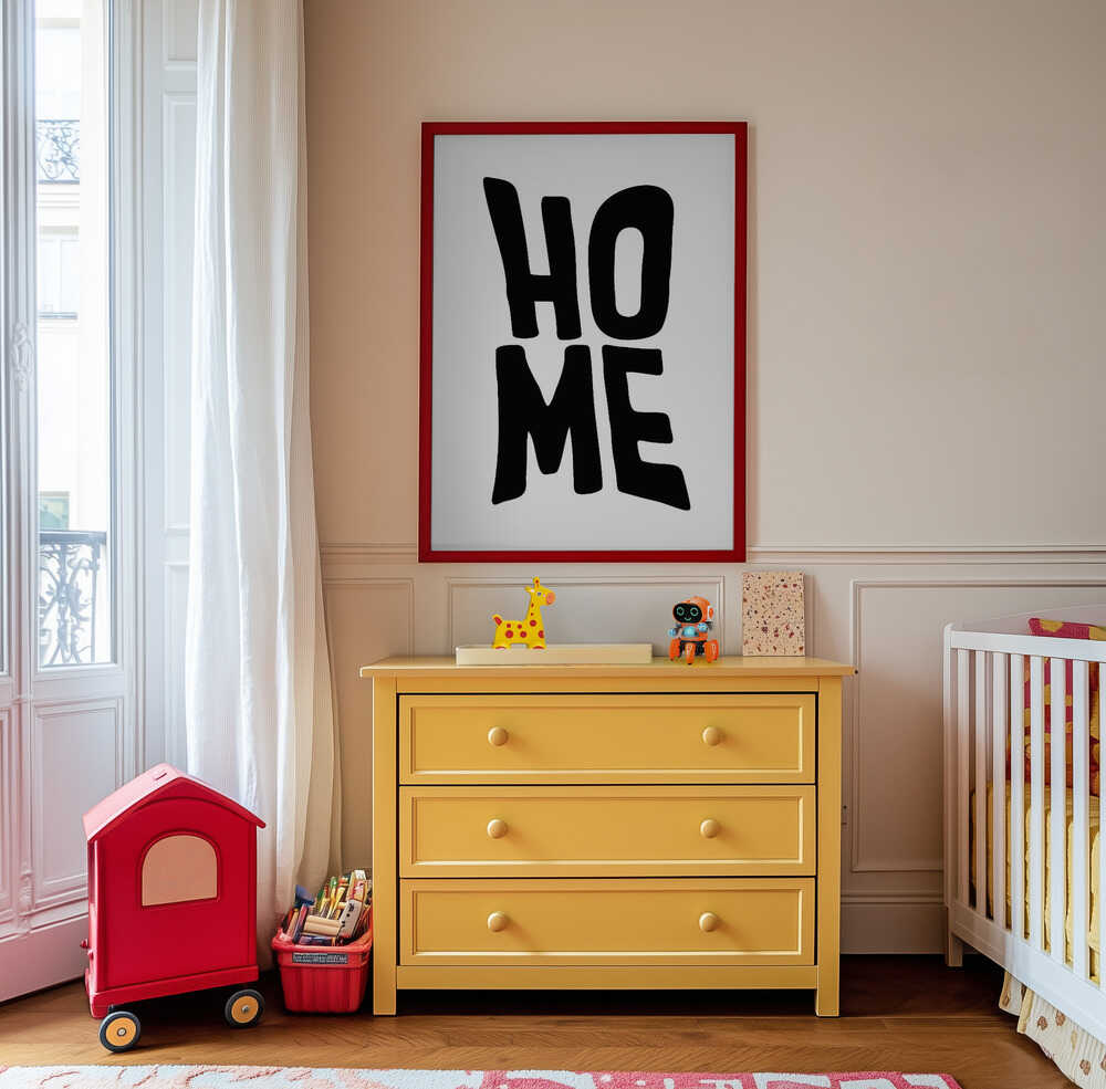 Framed nursery poster with the text 'HOME' written in black hanging on the wall in the nursery above a yellow piece of furniture.