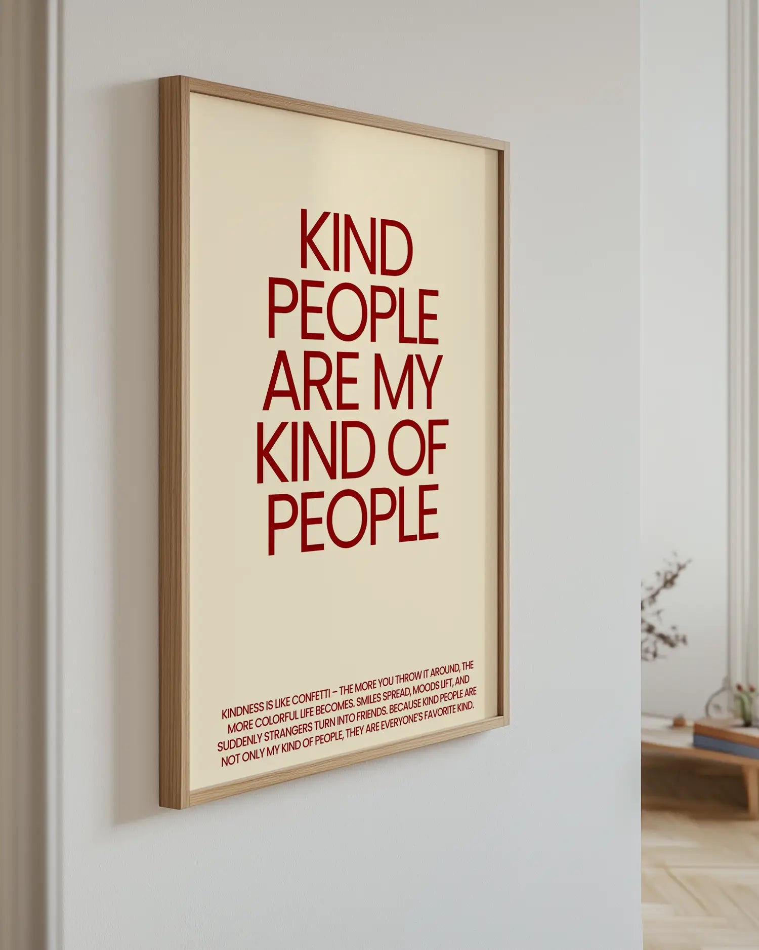 Framed poster with red text 'Kind people are my kind of people' on a white wall.