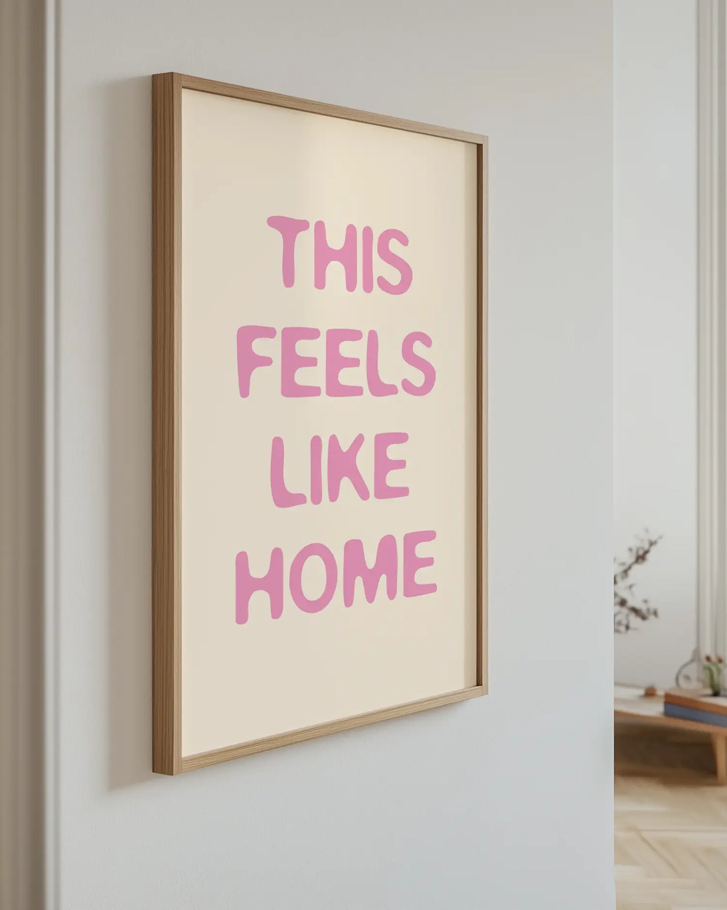 Artwork with 'This Feels Like Home' text in pink on a light background
