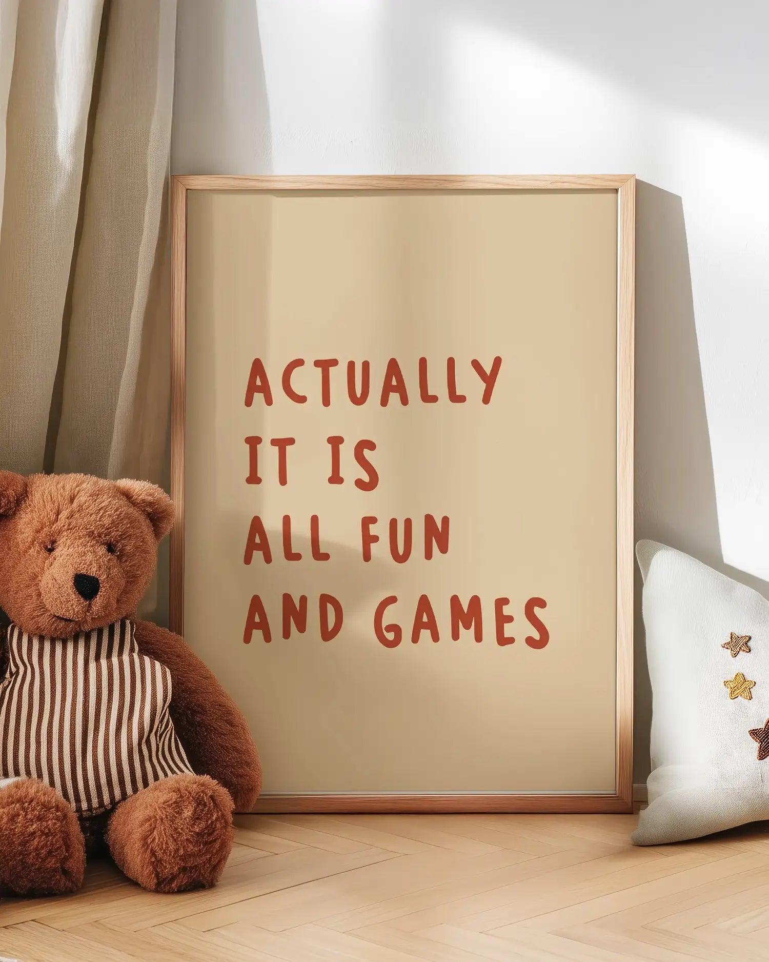 Poster with the quote 'Actually it is all fun and games' with a teddy bear on a wooden floor.