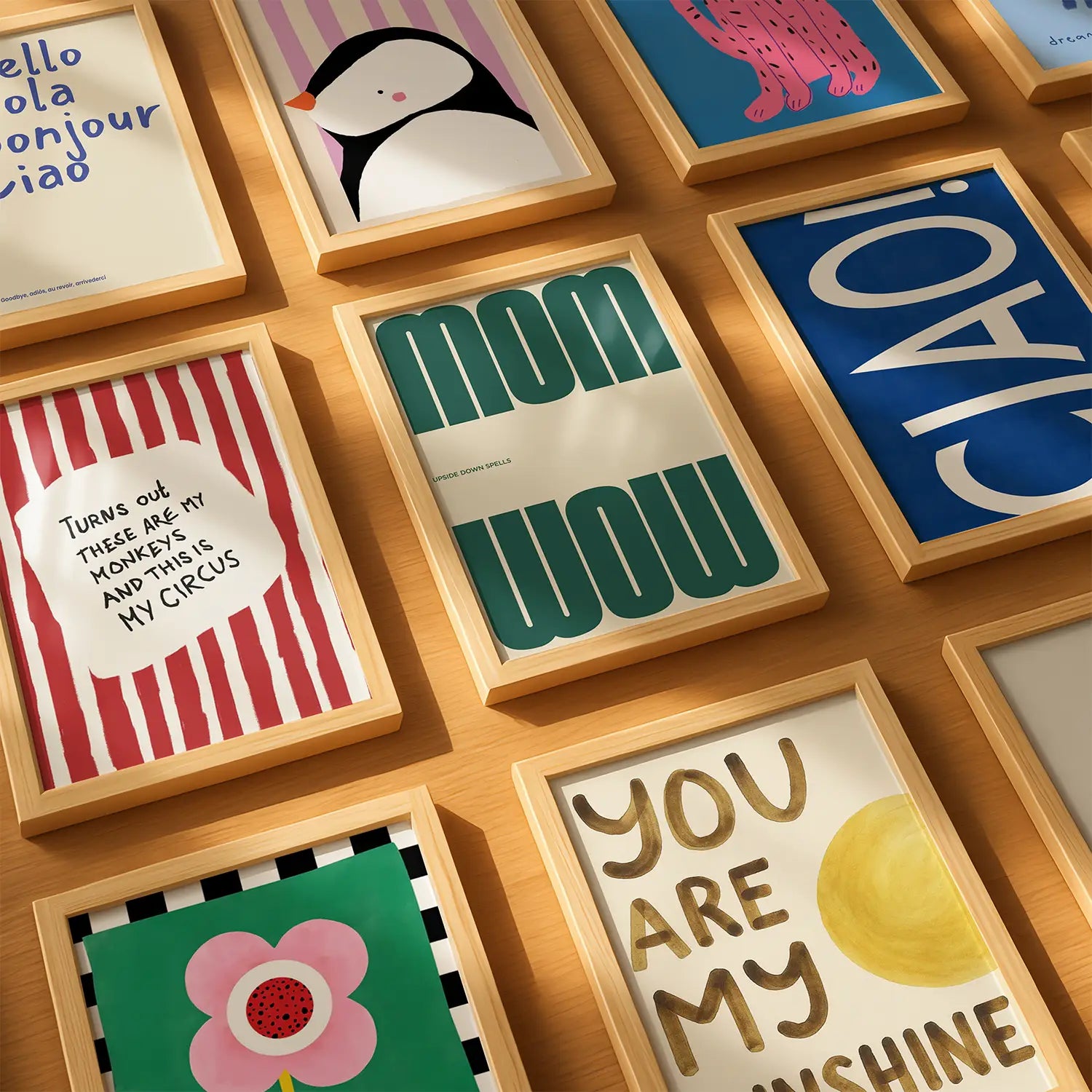 Collection of framed nursery posters with various designs and text on a wooden surface.