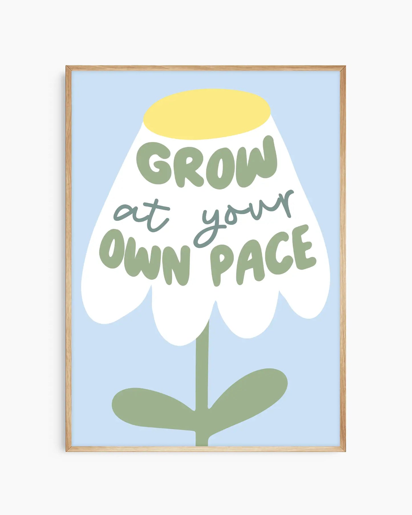 Framed artwork with a flower illustration and text 'Grow at your own pace' on a light blue background.