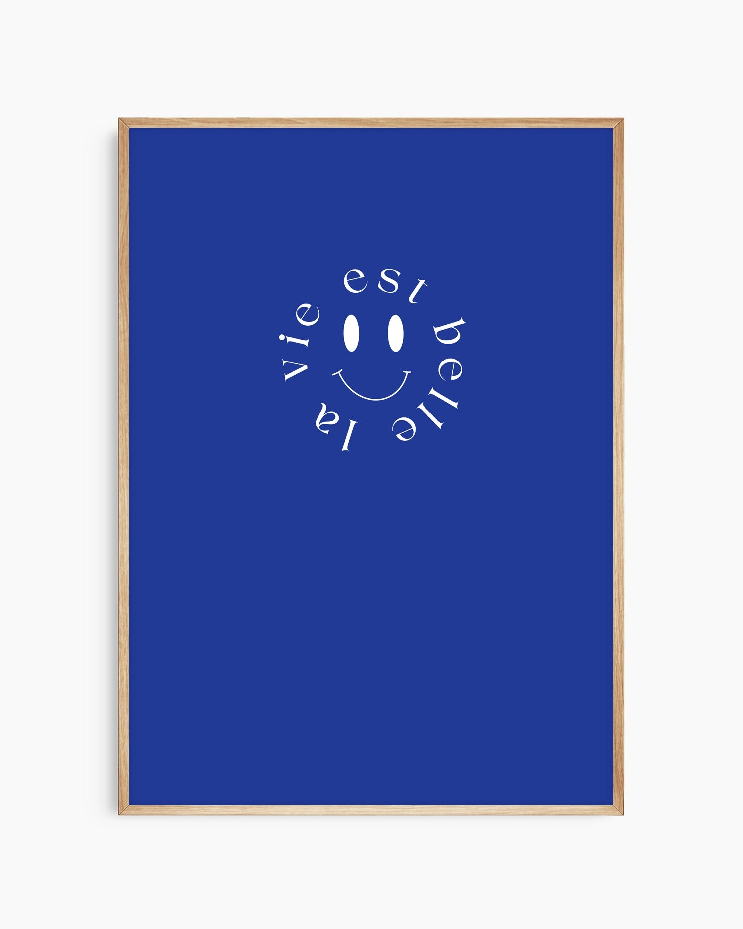 Framed artwork with a smiley face and 'La vie est belle' text on a blue background