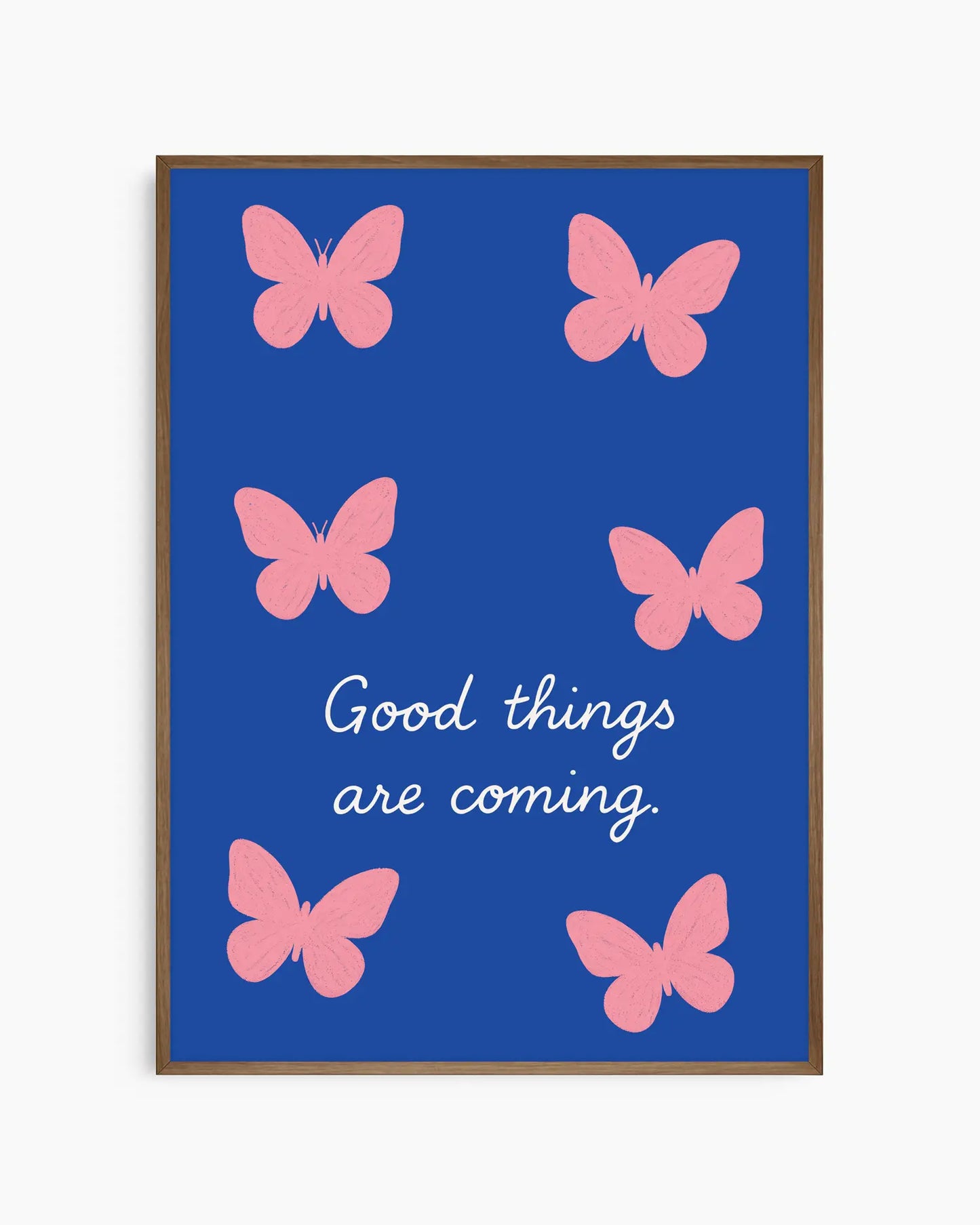 Framed artwork with pink butterflies and 'Good things are coming' text on a blue background