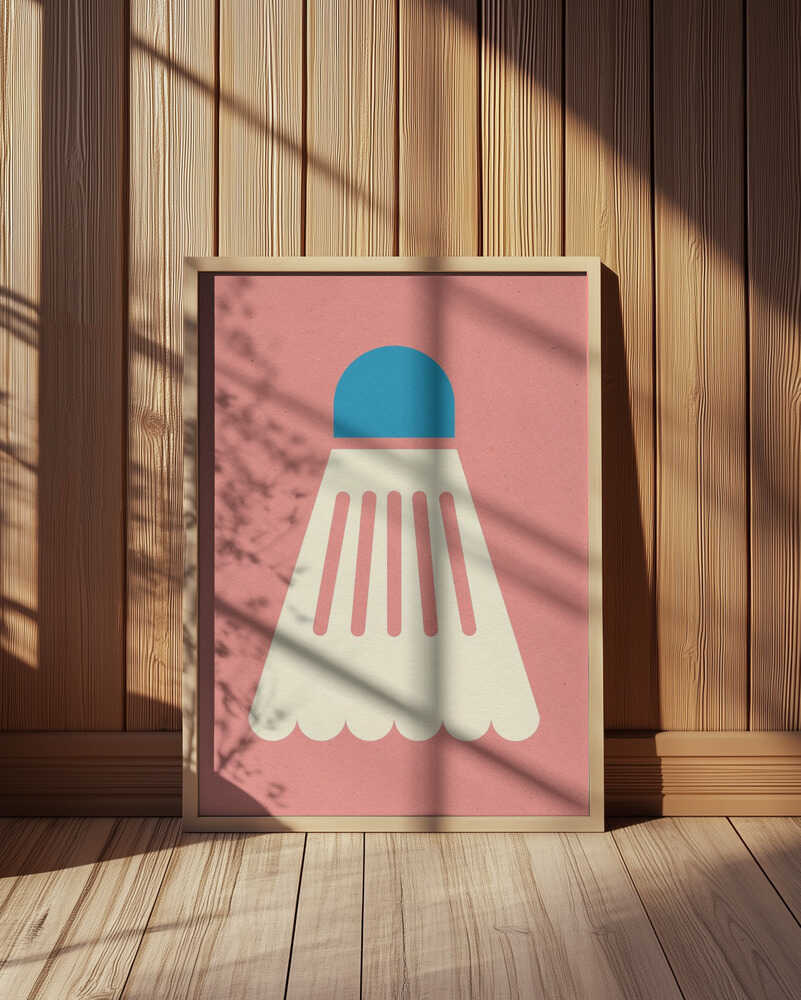Framed minimalist badminton shuttlecock poster with a pink background and blue top, sunlight casting gentle shadows on the wood-paneled wall.