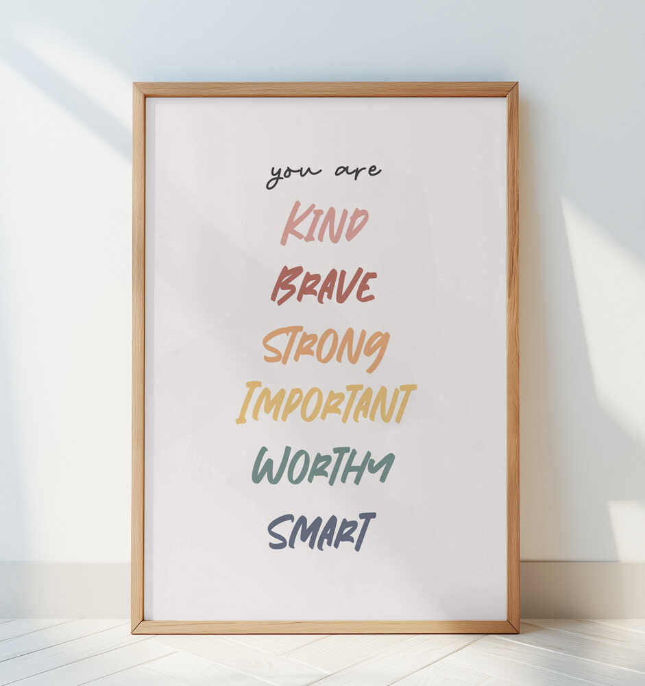 Framed affirmation print displayed in a bright minimal room. Soft handwritten text reading “You are kind, brave, strong, important, worthy, smart,” perfect for Scandinavian nursery decor, kids room encouragement art, and mindful home styling.