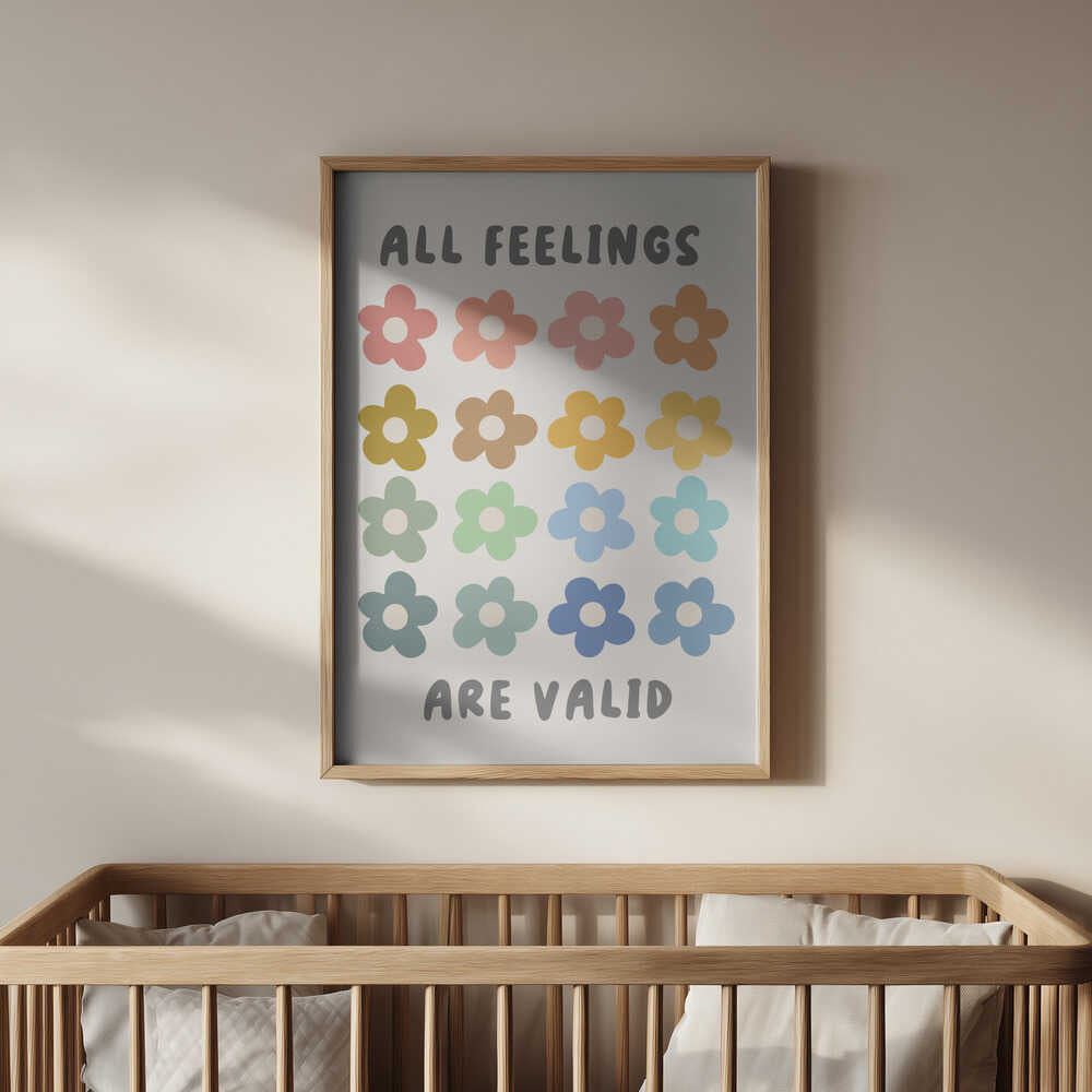 Framed “All feelings are valid” print hanging above a wooden crib. Soft pastel flower icons and comforting affirmation, creating a warm and emotionally supportive nursery environment.