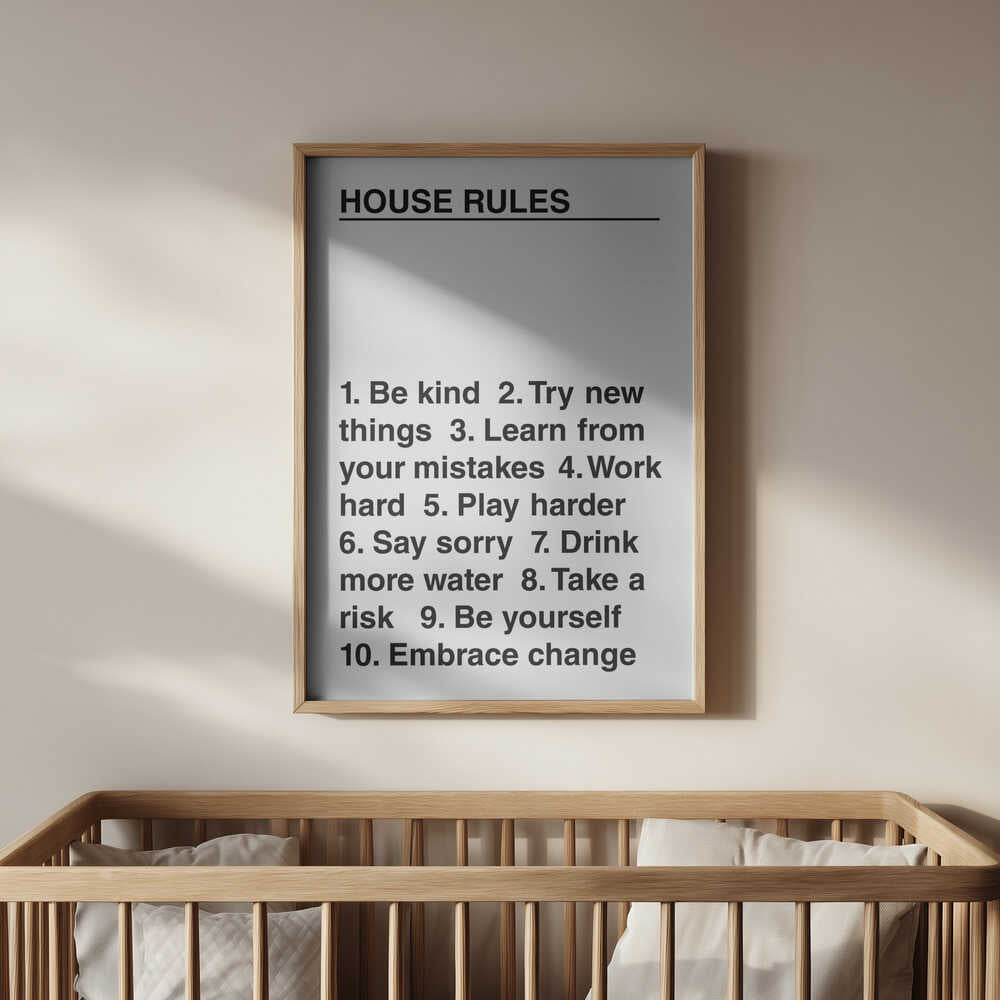 Minimalist black and white poster reading “House Rules,” featuring uplifting reminders about kindness, growth, and courage. Framed in light wood and hanging above a baby’s crib — a timeless and encouraging piece for a loving nursery.